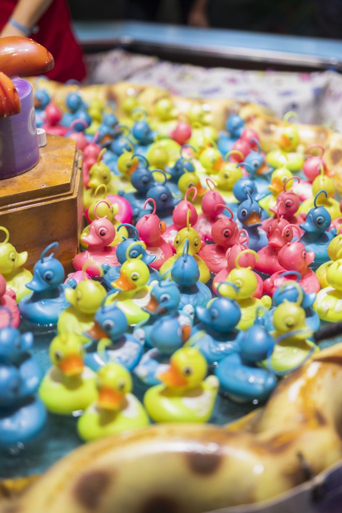 Organisez une pêche aux canards colorée : un stand qui plaît quelque soit l'age Vue rapprochée de canards colorés en plastique pour un jeu de pêche aux canards lors d’une kermesse