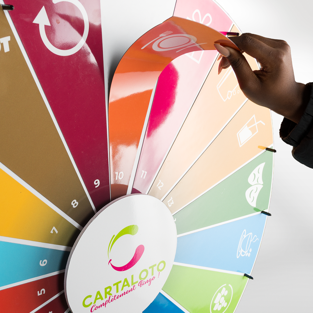 Main retirant une section magnétique orange d'une roue de loterie pour changer facilement le visuel du jeu.